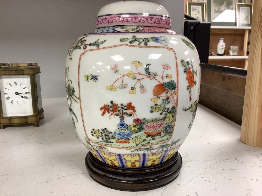 A pair of Chinese famille rose jars and covers, late 19/early 20th century, 15.5cm, on hardwood stands